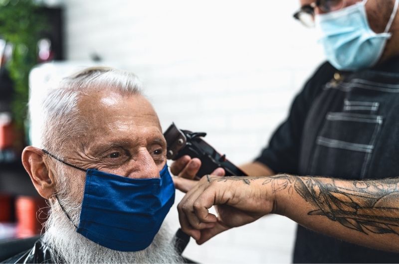 Man being serviced by a mobile barber in a aging care community